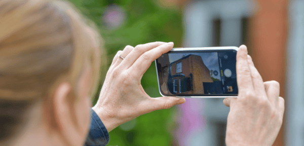 Image shows surveyor photographing a property
