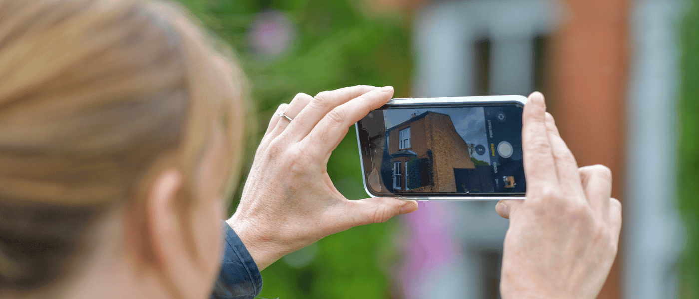 Image shows surveyor photographing a property