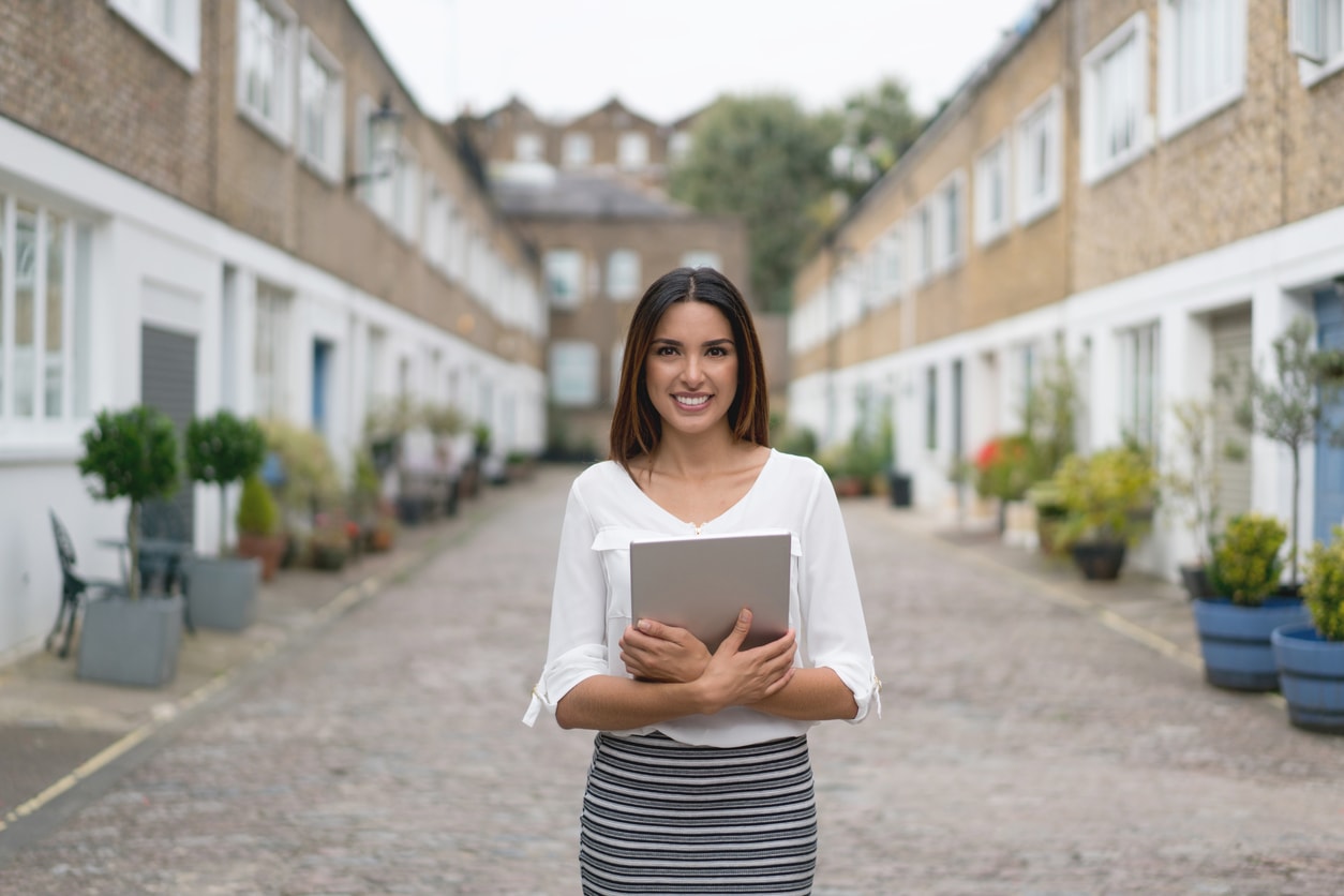 Woman estate agent looking at mews houses in London
